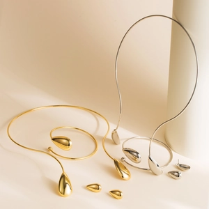 Conjunto de joyas minimalistas de metal pulido con collar de torque y brazalete de gota