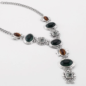 Makroaufnahme einer Vintage-Barockkette mit antikem Silberfinish und bunten Edelsteinen