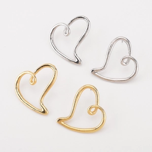 Gros plan de boucles d'oreilles cœur évidées minimalistes en finitions or et argent