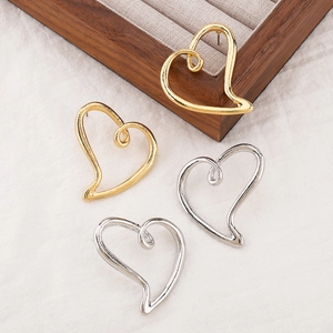 Boucles d'oreilles cœur creux dorées et argentées sur une boîte de rangement à bijoux