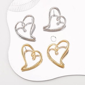 Gros plan détaillé des boucles d'oreilles cœur évidé en finitions or et argent