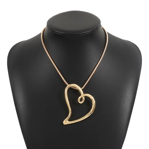 Détail du pendentif cœur doré ajouré sur un collier à chaîne serpent métallique chic