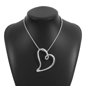 Vue détaillée du pendentif cœur argenté avec chaîne serpent sur un présentoir noir