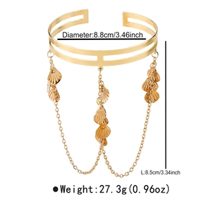 Detailed view of bohemian gold arm cuff with shell pendants and fringe chains