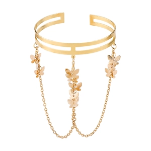 Detailed view of gold butterfly arm cuff with delicate dangling chain tassels