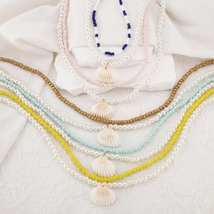 Detalle de colgantes de concha bohemios hechos a mano con cuentas de colores de verano