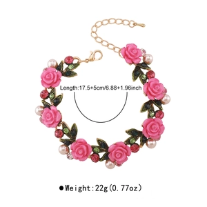 Detalle de pulsera floral con rosas de resina rosa y perlas blancas en cadena dorada