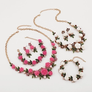 Detalle del conjunto de joyas florales con rosas de resina, perlas y strass en oro
