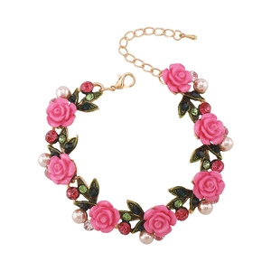 Vista detallada de pulsera de rosas de resina rosa con perlas blancas y cierre de langosta
