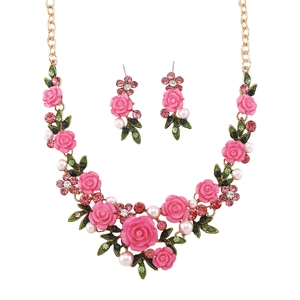 Detalle de conjunto joyeria floral con rosas de resina rosa, perlas blancas y brillantes