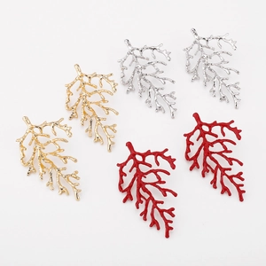 Detailed view of coral branch earrings in gold, silver, and vibrant red finishes