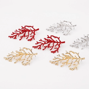 Detailed view of coral branch earrings in glossy red, shiny silver, and gold finishes