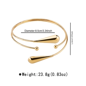 Détail macro d'un bracelet de bras doré géométrique avec gouttes et perles