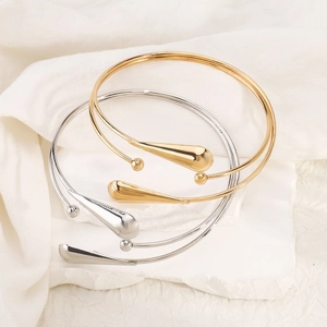 Gros plan de bracelets de bras géométriques avec pendentifs en forme de goutte d'eau