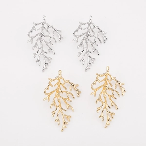 Detailed view of branch-shaped earrings in gold and silver finish with natural texture