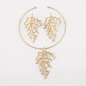 Macro shot of gold coral branch necklace and earring set with natural textured finish