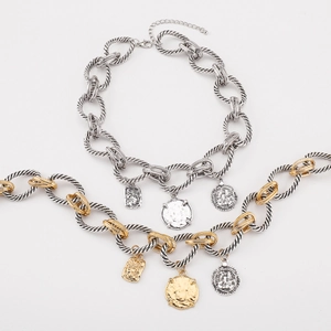 Detailed view of heavy chunky link chain necklace with vintage coin pendants in mixed tones
