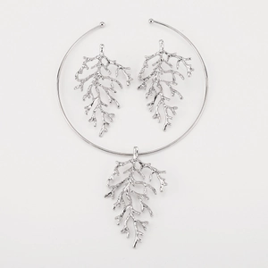 Detailed close-up of silver coral branch jewelry set with necklace and earrings