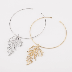 Detail of coral-shaped gold and silver branch pendant necklaces on thin metal chokers