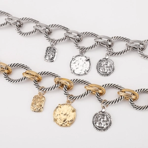 Detail of twisted rope chain necklaces with vintage coin pendants in gold and silver finish