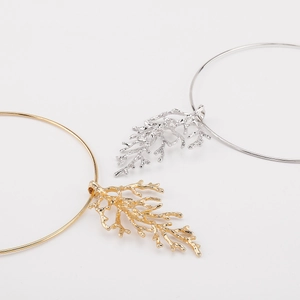 Close-up of gold and silver coral branch pendants with realistic textured details