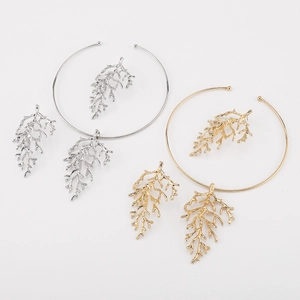 Detailed view of gold and silver coral branch necklace and matching earring set