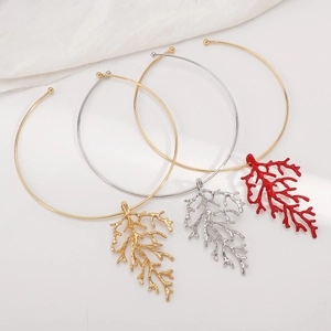 Macro detail of minimalist coral branch pendant necklaces in gold, silver and red finish