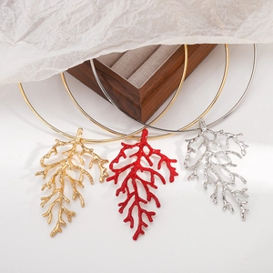 Three-color coral branch necklaces in gold, red, and silver finishes on a wooden jewelry box
