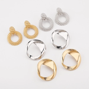 Vue détaillée de boucles d'oreilles rondes en alliage avec textures tissées et design torsadé