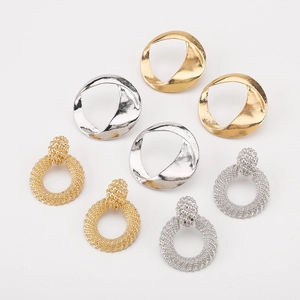 Détail macro de créoles torsadées dorées et argentées et bijoux en alliage à texture tressée
