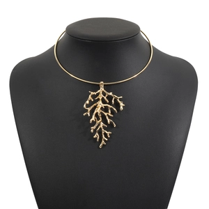 Macro shot of gold coral branch pendant on a choker necklace for beach fashion style