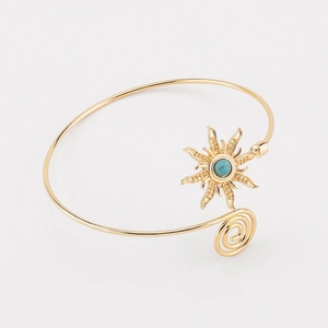 Detailopname van turkoois zonnebloemmotief en spiraalontwerp op de gouden armband