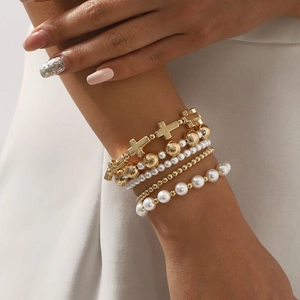 5-piece stackable beaded bracelet set featuring golden cross and white pearls