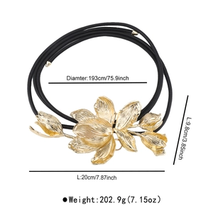 Detail of vintage gold tulip flower buckle on a black slim leather rope waist belt