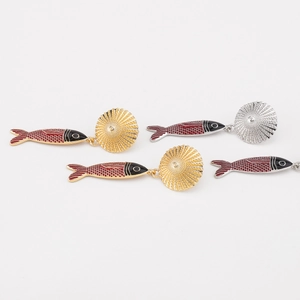 Dettaglio di orecchini a pesce con smalto rosso e nero in finitura oro e argento