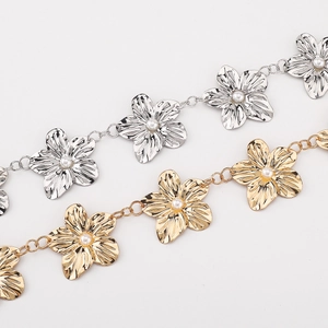 Détail de la chaîne de corps fleur dorée et argentée avec centre en perle blanche