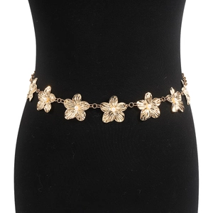 Détail de la chaîne de taille fleurie dorée avec perles sur un mannequin noir