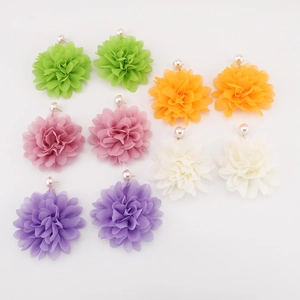 Primer plano de aretes de flores de gasa coloridos con elegantes detalles de perlas