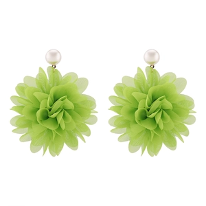 Detalle macro de pendientes de flores en tela verde hierba con perlas blancas