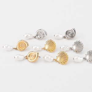 Detail of vintage shell earrings with baroque pearls in gold and silver finishes