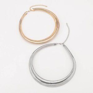 Detail of gold and silver torque necklaces with ribbed texture and adjustable lobster clasps