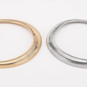 Detail showing the textured metallic snake bone surface of gold and silver chokers