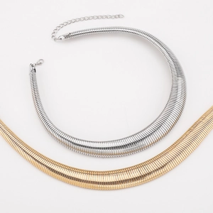 Close-up of ribbed metal choker texture with lobster clasp and extension chain