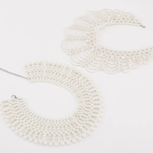 Detailed view of hand-woven faux pearl collars with elegant lace and grid patterns