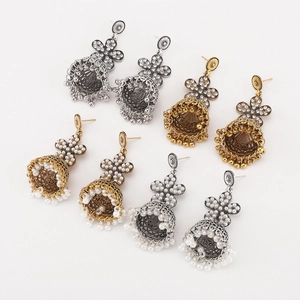Macro detail of Bohemian Jhumka bell earrings with rhinestones and white pearls set