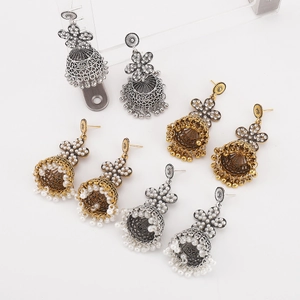 Detail view of Bohemian floral bell earrings in gold and silver finish with rhinestones