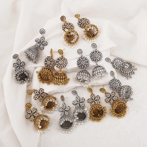 Detail of vintage bohemian Jhumka earrings with bells, pearls, and floral carvings