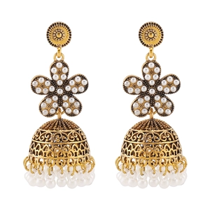 Macro shot of vintage golden Jhumka earrings with white pearls and flower detail