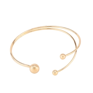 Detailed view of a gold double-layer open bangle with minimalist sphere ends