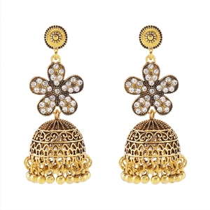 Detail of vintage Indian Jhumka gold earrings with flower stud and bell tassel